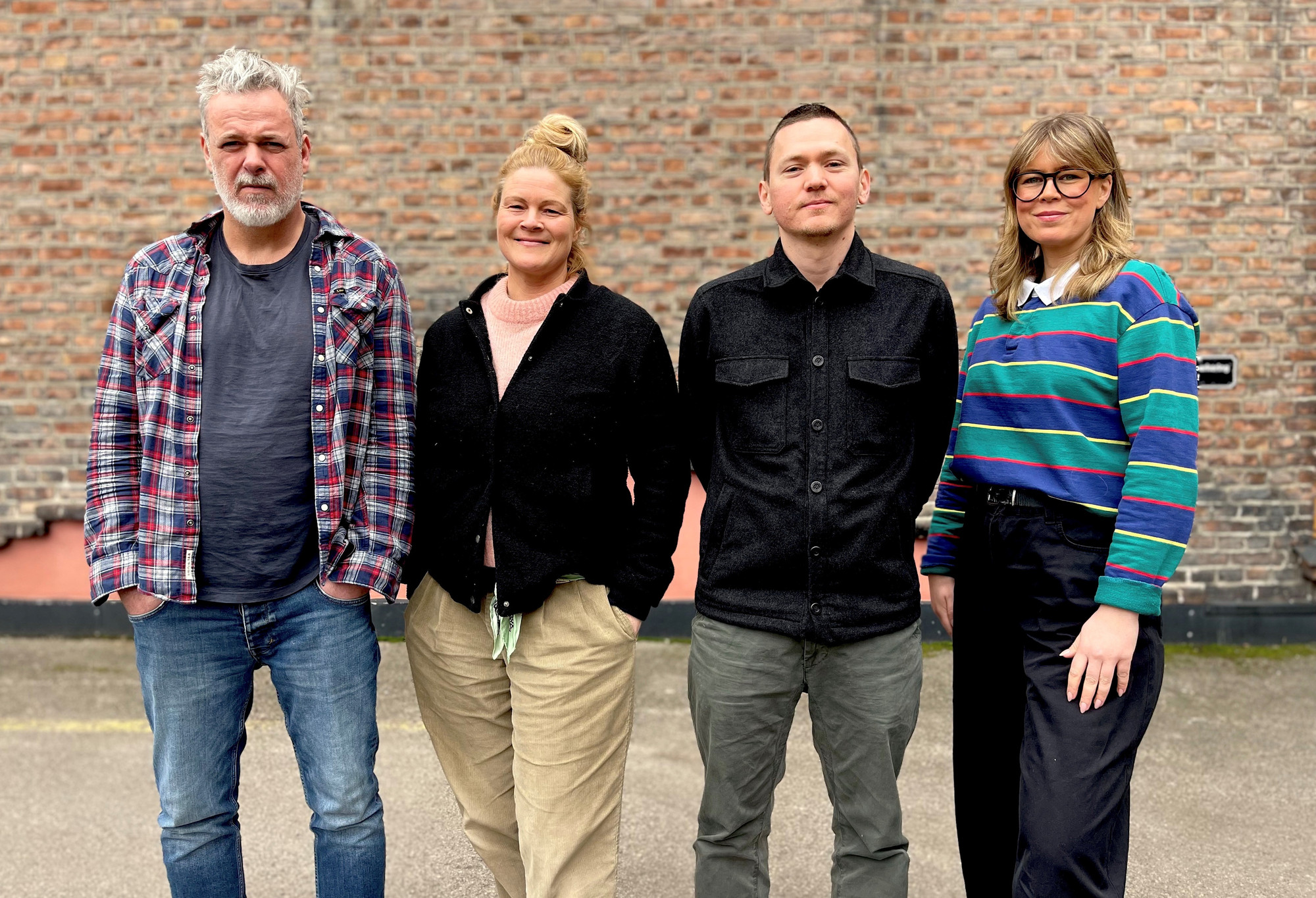 Foto. Fire personer på en rekke. To menn og to kvinner.