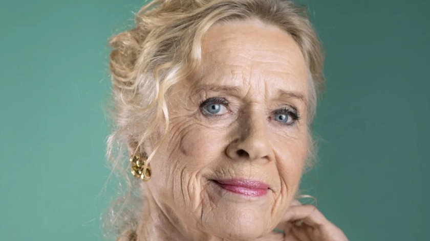 Foto. Portrettbilde av en eldre dame med lyst oppsatt hår.
